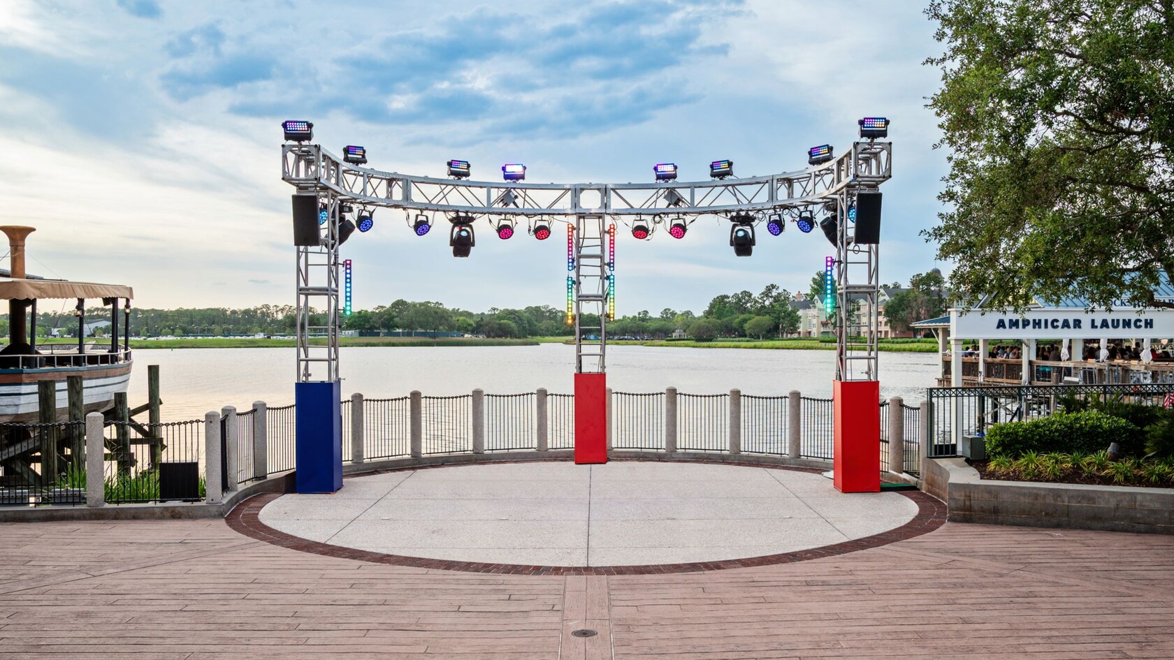 A circular stage in front of the lake at Waterview Park, framed by overhead lighting