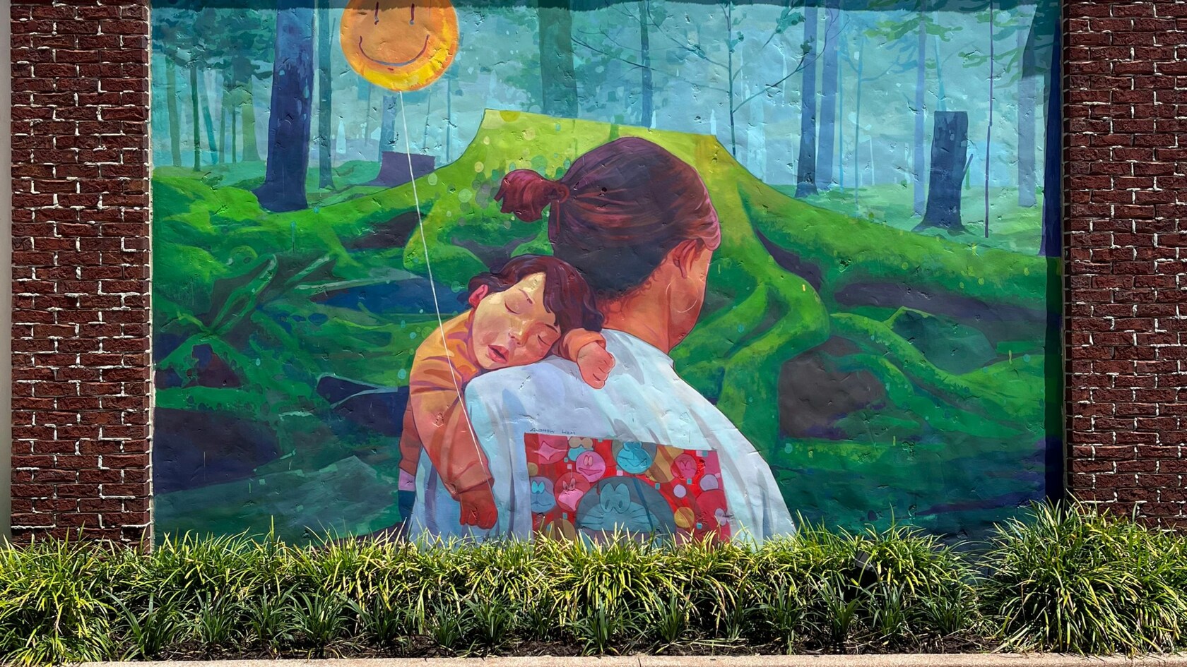 Un mural de una madre caminando por un bosque mientras sostiene a su hijo que duerme 