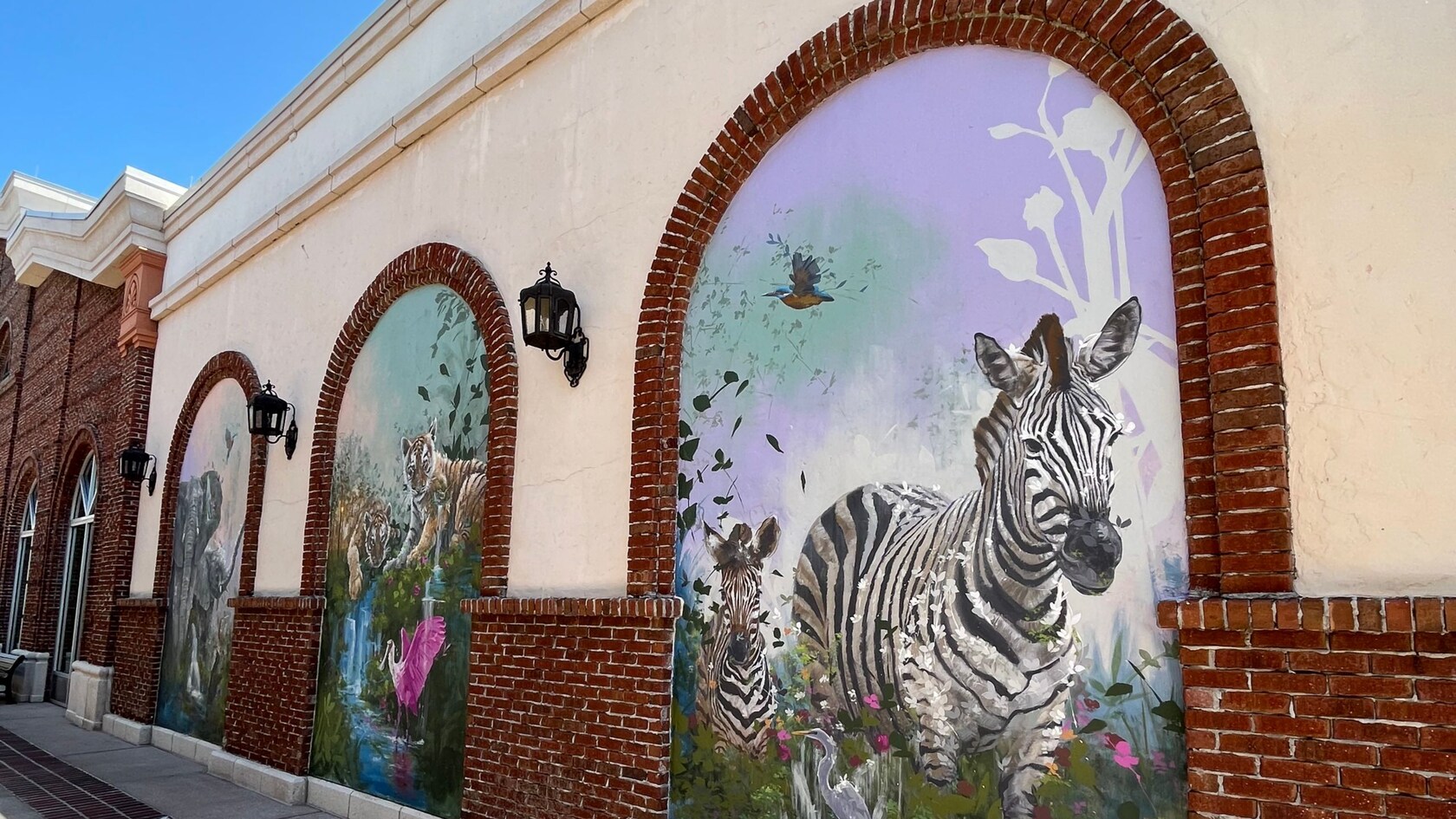 Un tríptico en una pared de Disney Springs lleno de elefantes, tigres y cebras