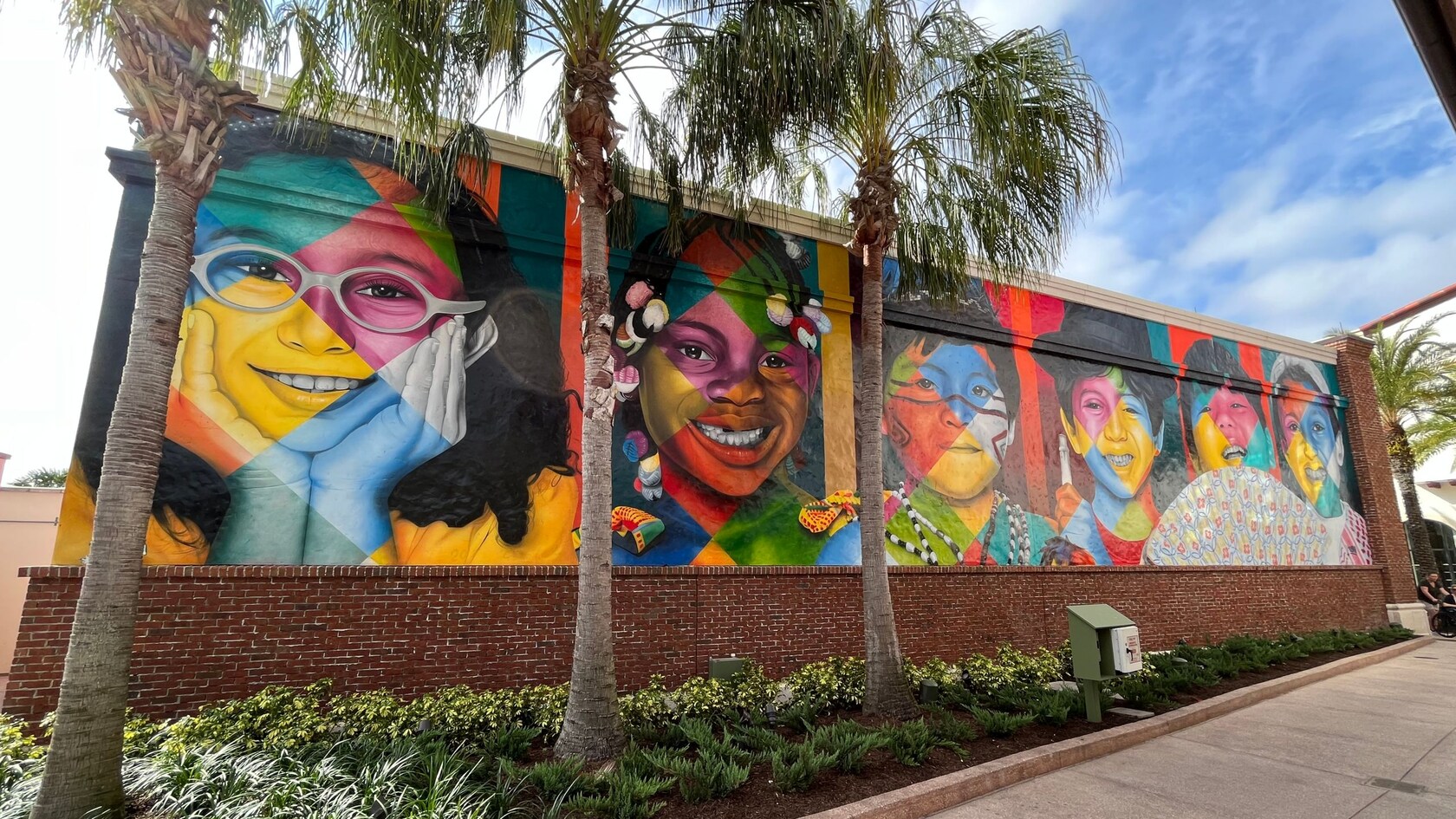 Un mural en una pared de ladrillo con imágenes realistas de niños