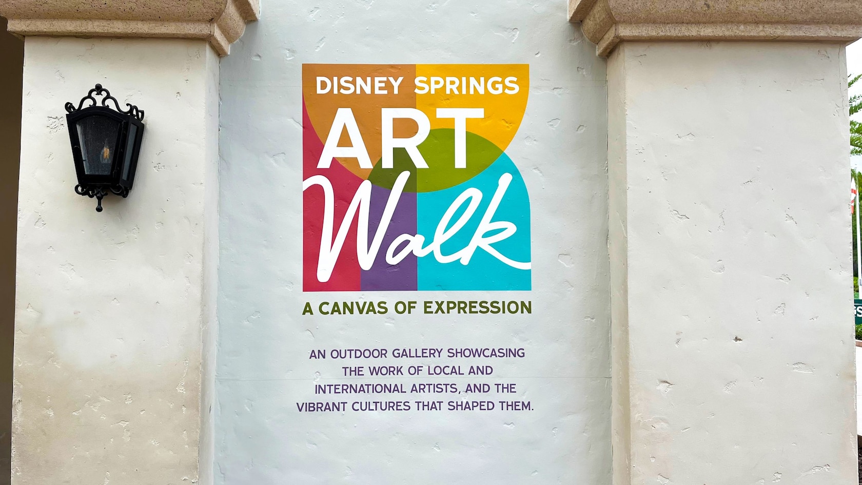 El logotipo de Art Walk sobre una pared en blanco con texto debajo que dice ‘A Canvas of Expression’
