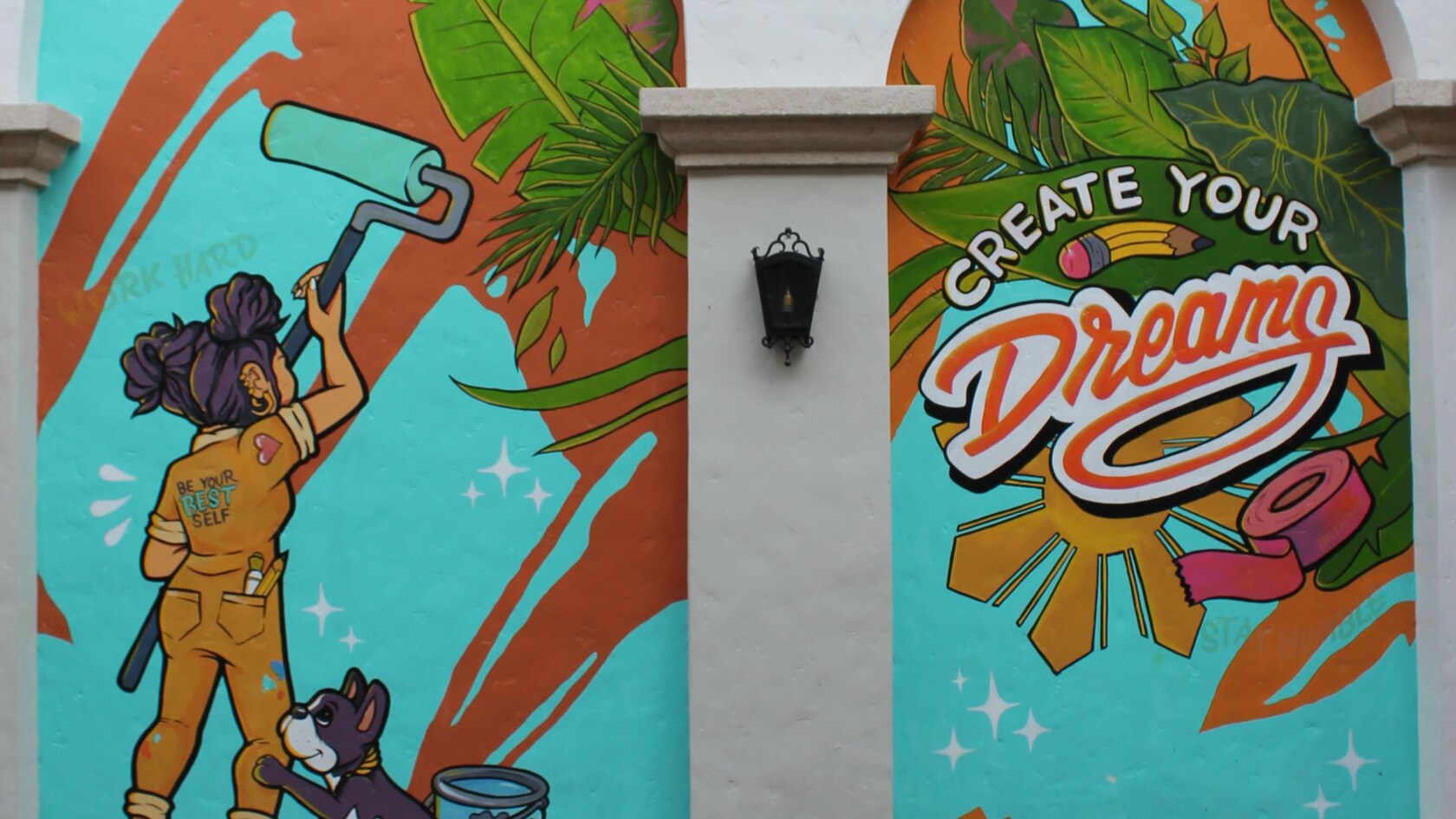 Un mural de un cachorro viendo a una niña que pinta