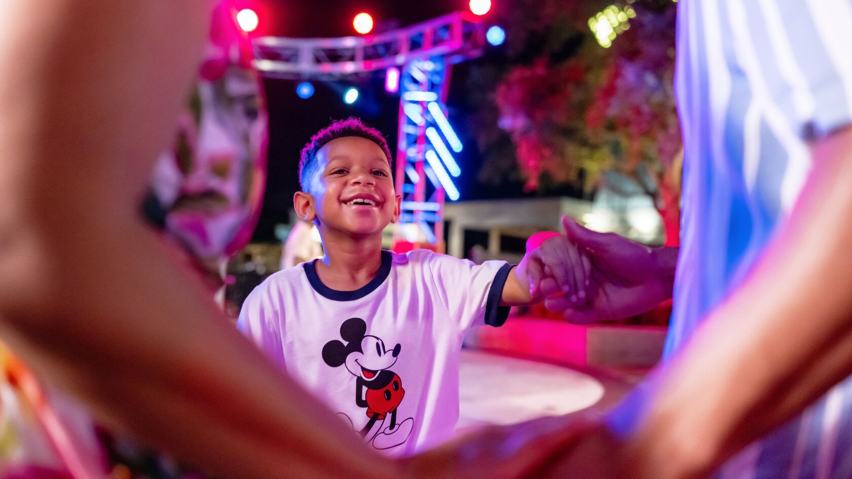 A boy holding hands and dancing with a group of people