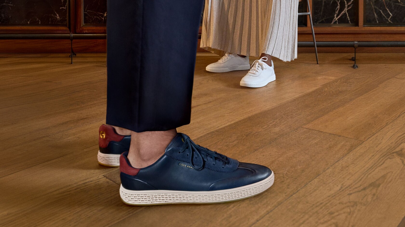 The feet of a man and a woman wearing Cole Haan sneakers