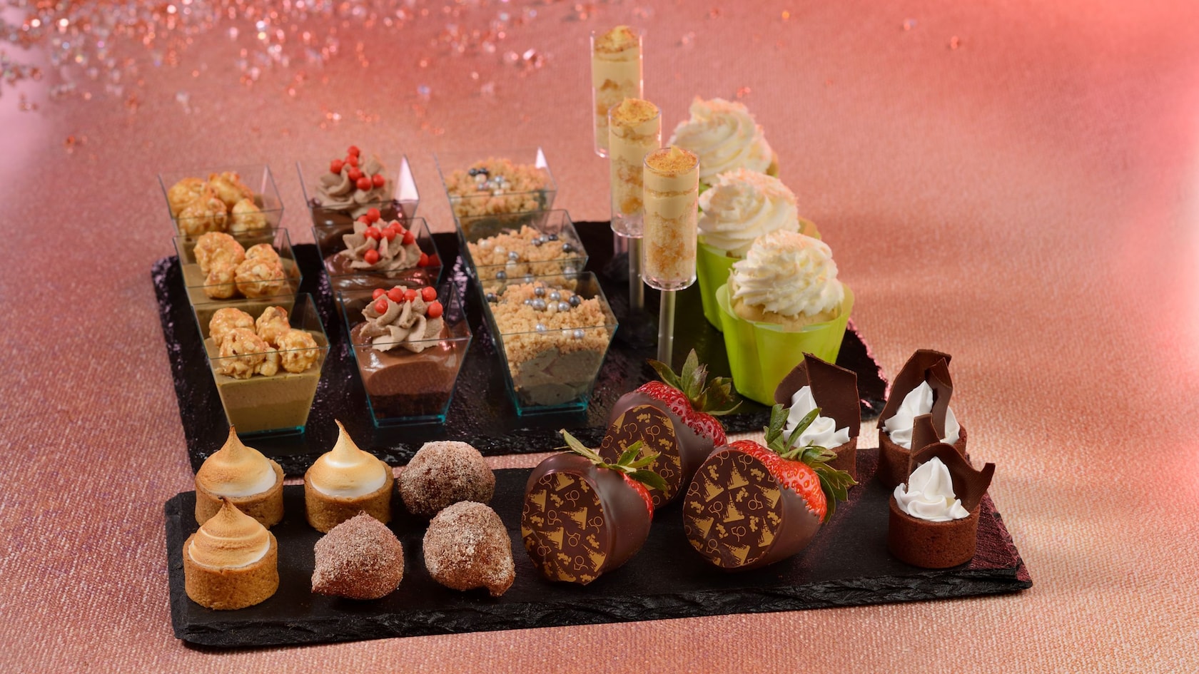 Trays holding 9 different desserts, including chocolate-covered strawberries, butterscotch pudding and pastries