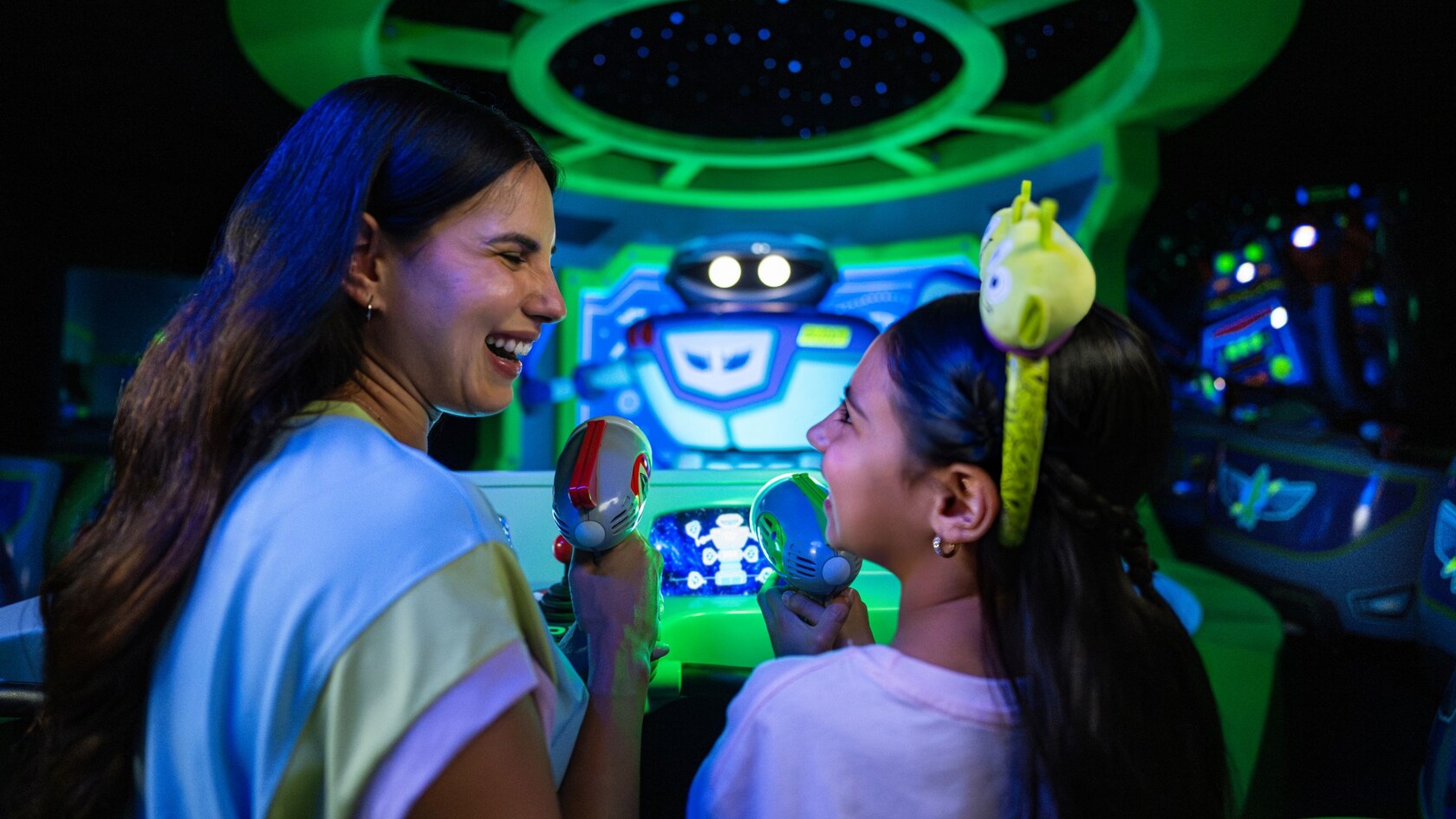 A mother and daughter smiling as they ride Buzz Lightyear's Space Ranger Spin at Magic Kingdom park