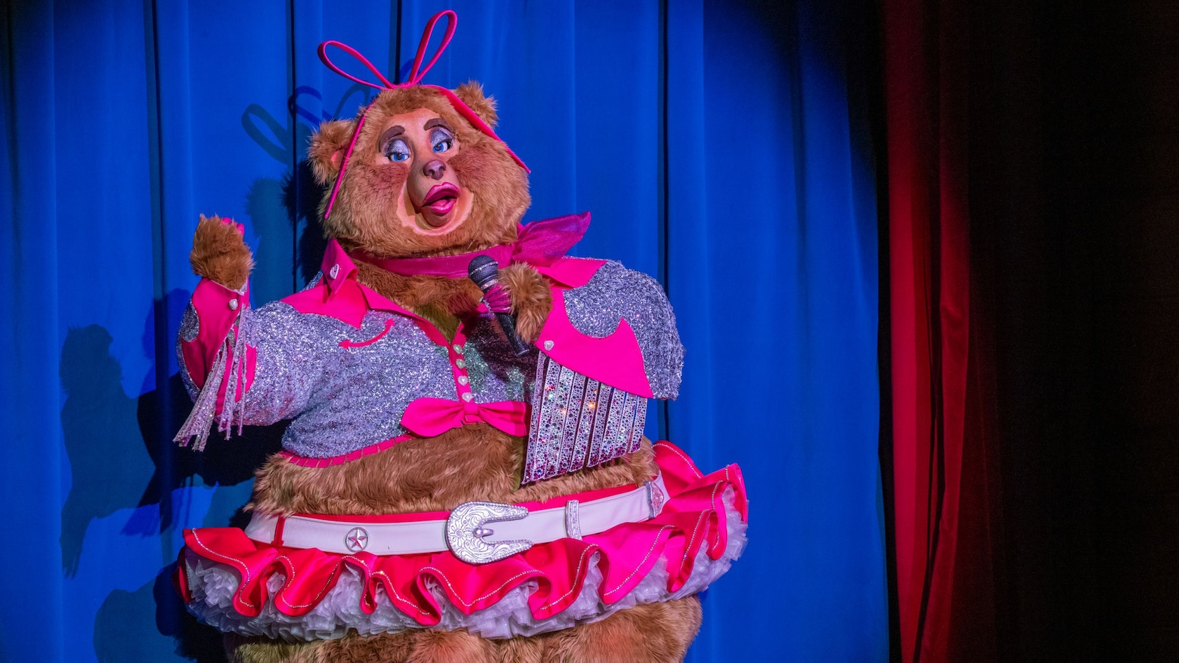 Trixie Saint Clare from the Country Bear Musical Jamboree show on a stage with a microphone