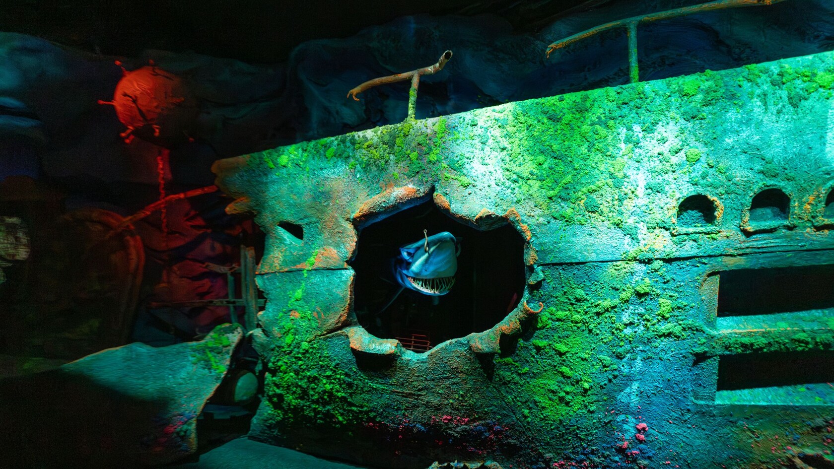 Chum the shark poking out of a hole in a sunken ship at The Seas with Nemo & Friends