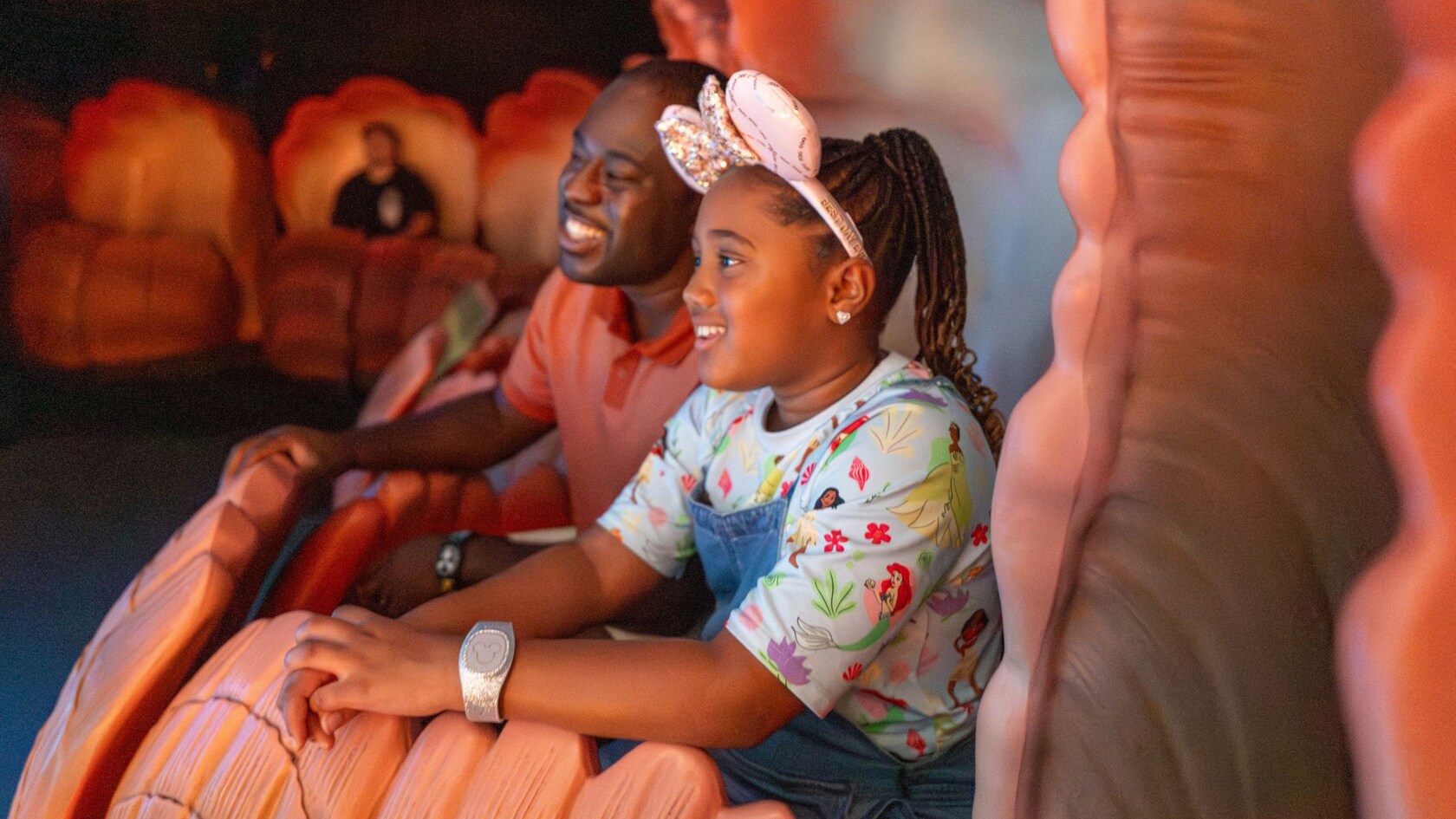 A father and daughter riding in a seashell at The Seas with Nemo & Friends