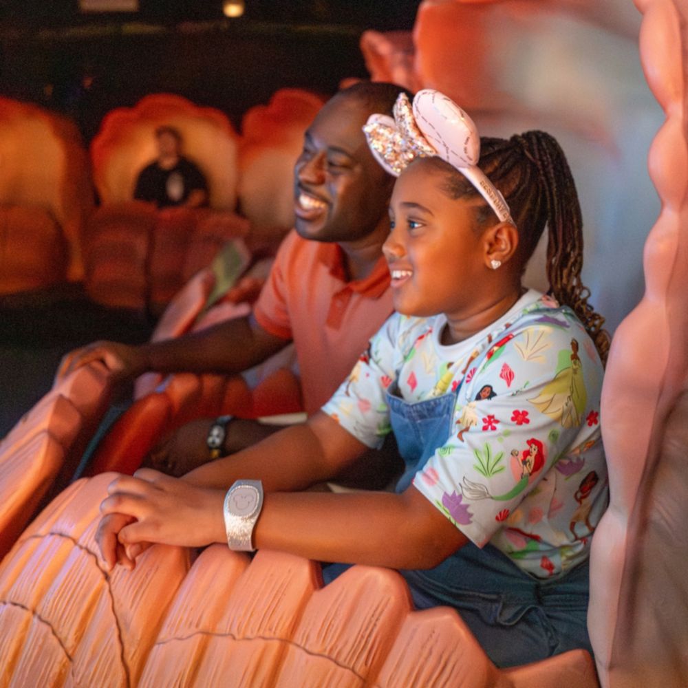 A father and daughter riding in a seashell at The Seas with Nemo & Friends