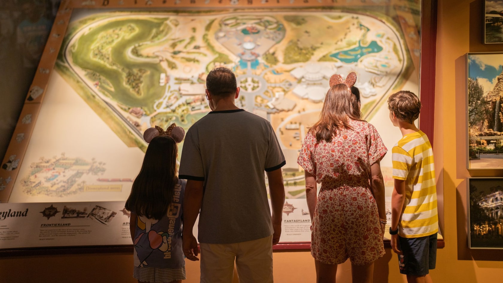 A family of 4 looking at a Walt Disney World Resort map in the Walt Disney Presents gallery at Disney’s Hollywood Studios