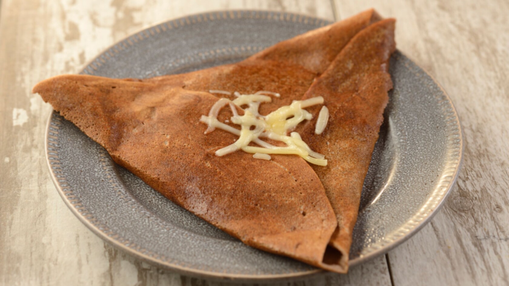 A triangle shaped galette topped with cheese