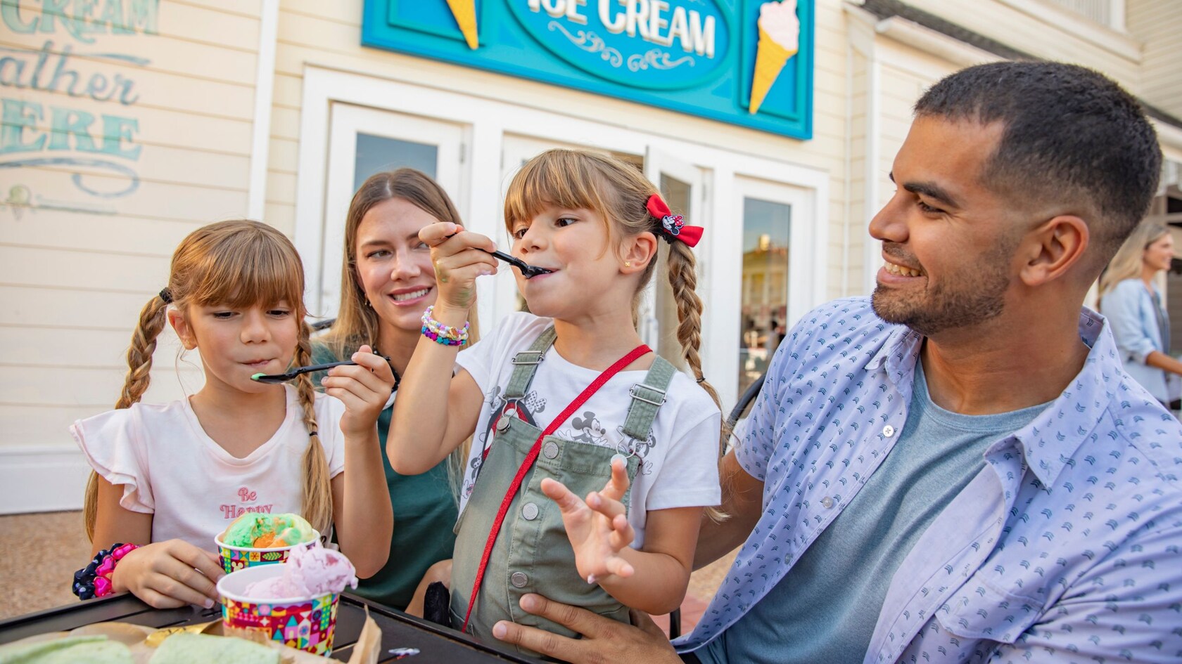 A family of 4 enjoys ice cream outside of Boardwalk Ice Cream in Walt Disney World Resort