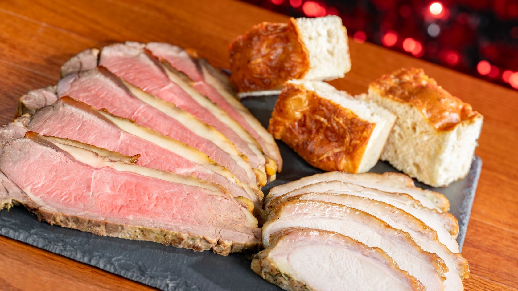 Slices of carved beef and turkey next to pieces of focaccia bread