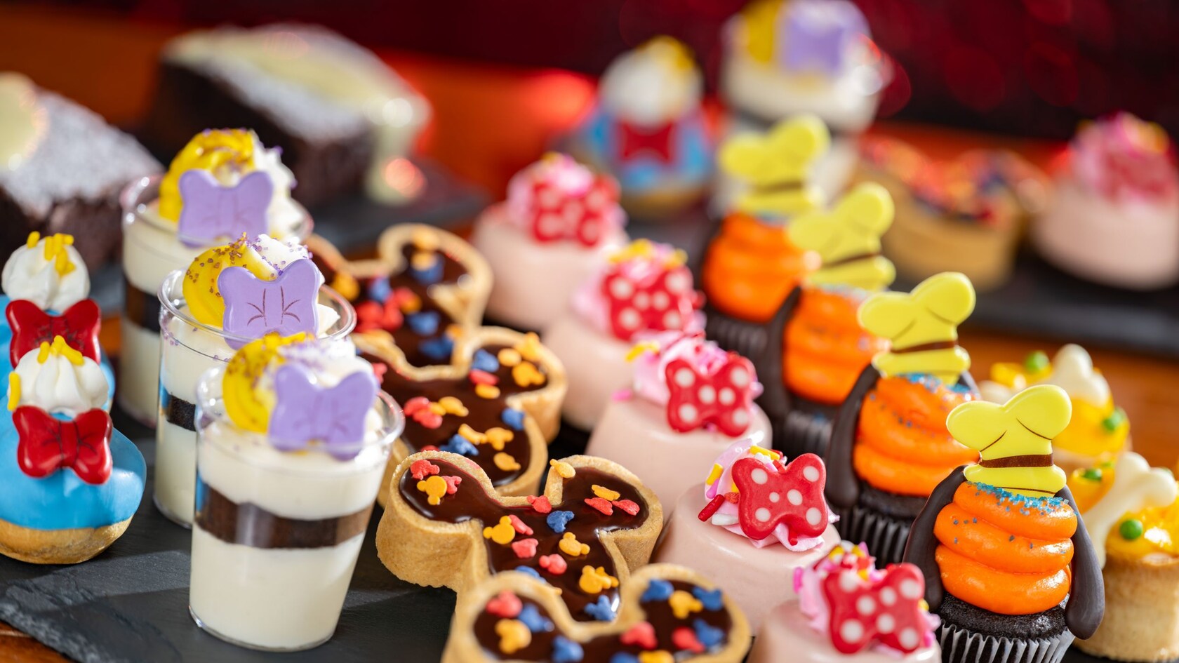 An assortment of bite sized desserts featuring a Mickey Mouse theme