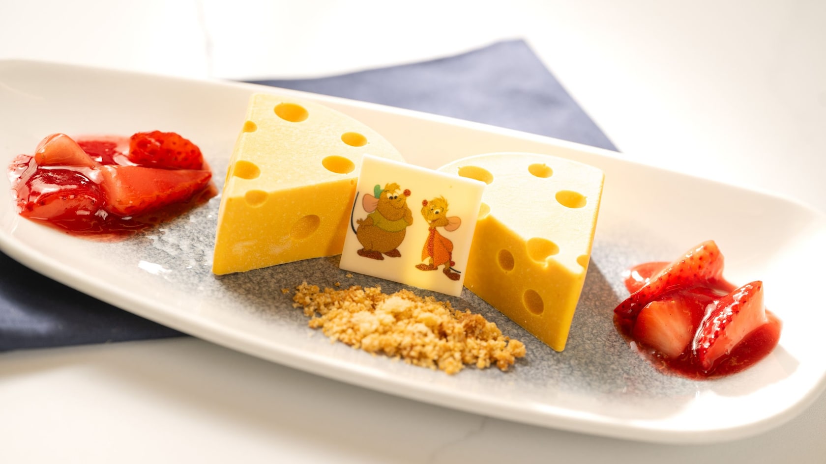 Two slices of Jaq and Gus Cheesecake that resemble Swiss cheese, along with fruit garnish