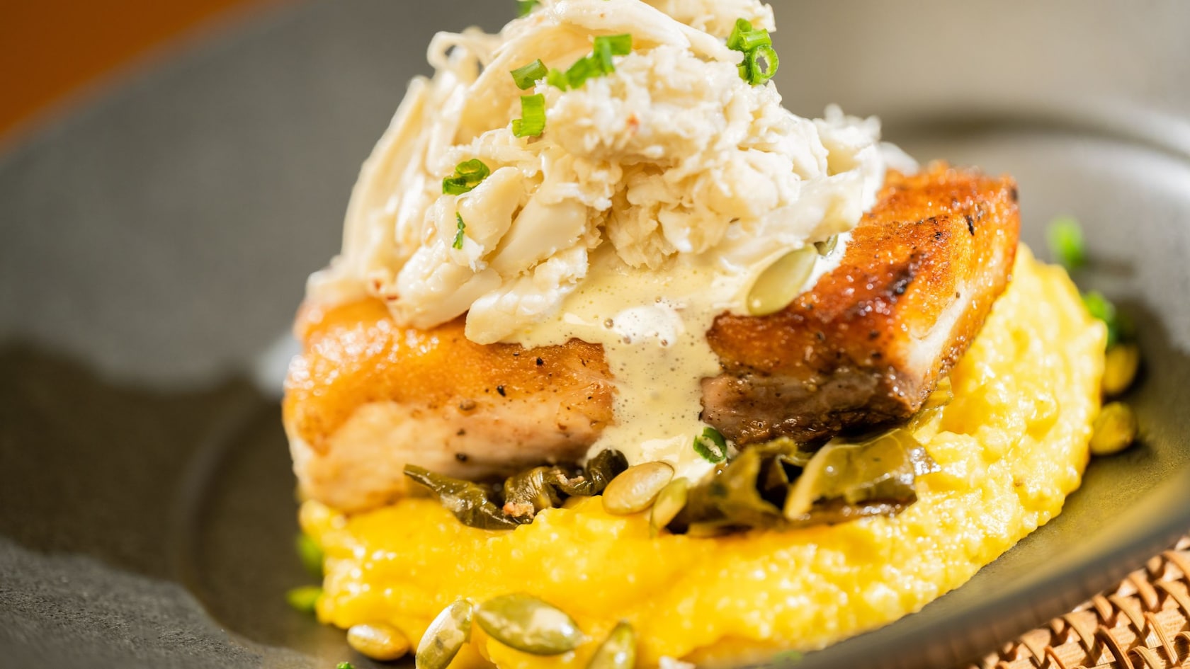 Crab topped Catch of the Day with grits and greens from Cinderella’s Royal Table restaurant