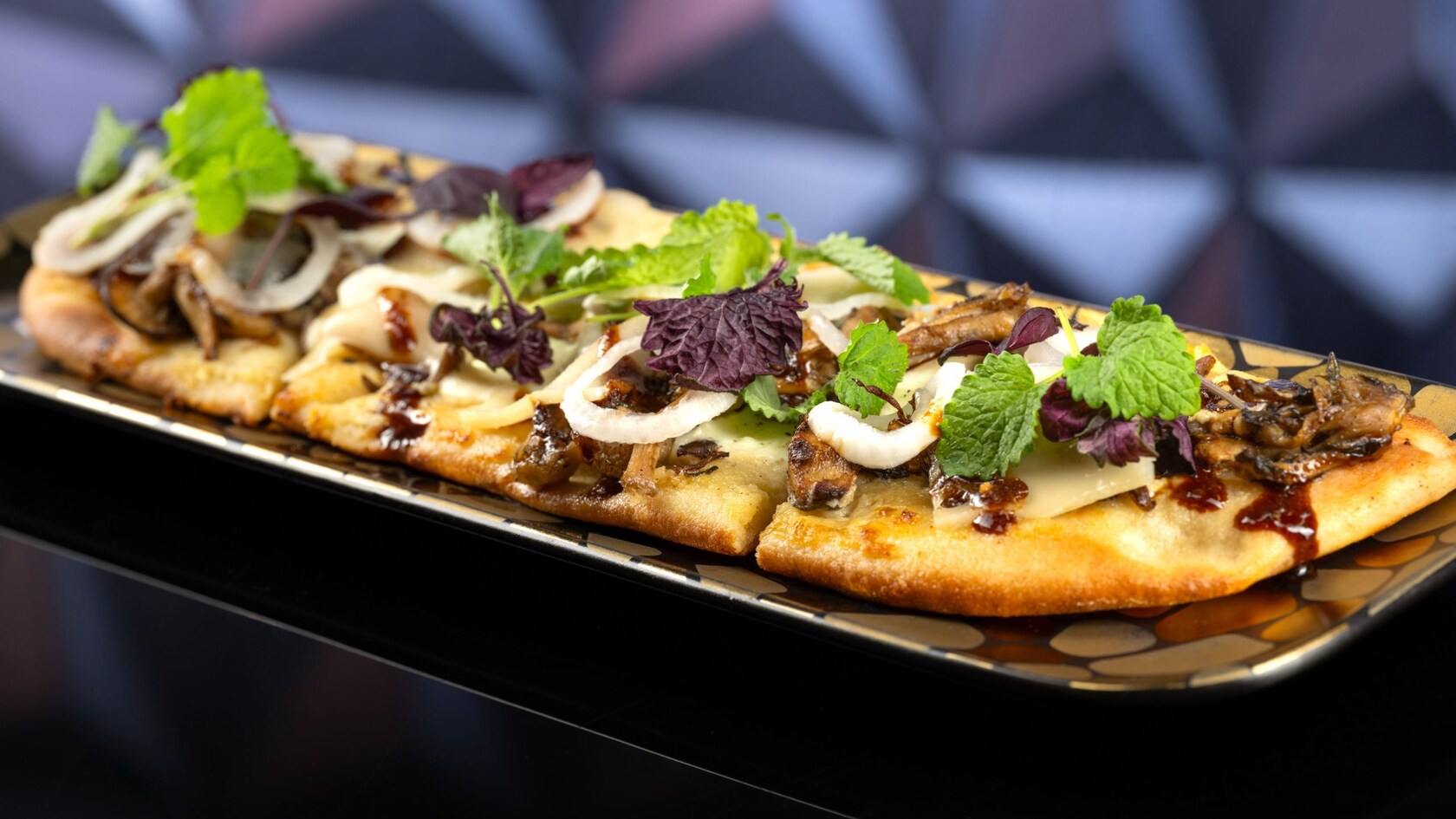 A flatbread pizza featuring mushrooms, herbs and sauce.