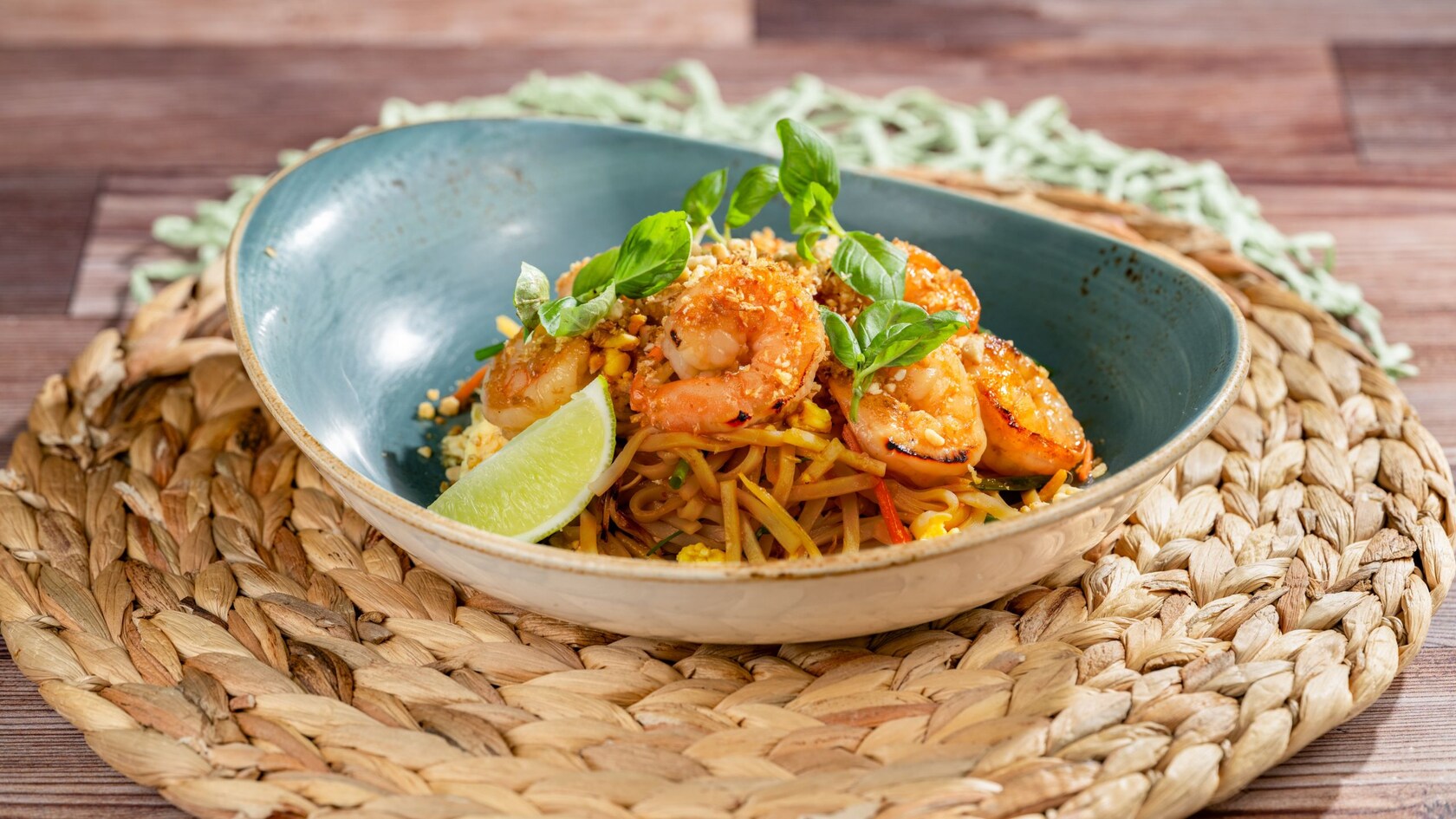Shrimp pad thai with rice noodles, crushed peanuts, fresh basil and a lime wedge