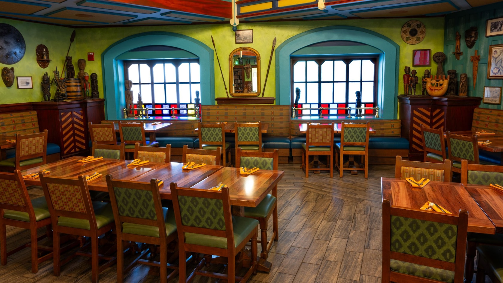A dining room decorated with carved wooden statues, masks and spears at the Jungle Navigation Company Limited Skipper Canteen