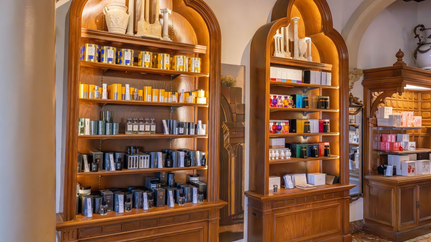 Three wooden display shelves holding fragrances and personal care items inside of Il Bel Cristallo at Epcot