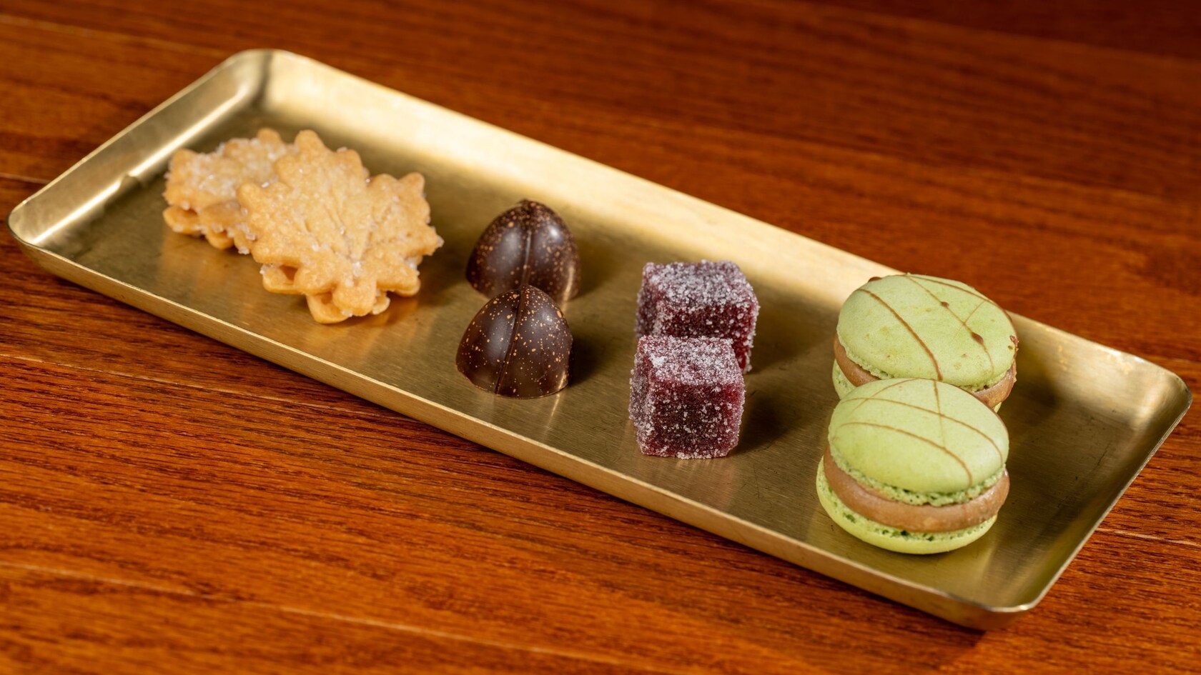 2 galletas de arce, 4 chocolates artesanales y 2 macarrones en una bandeja de latón de Le Cellier Steakhouse