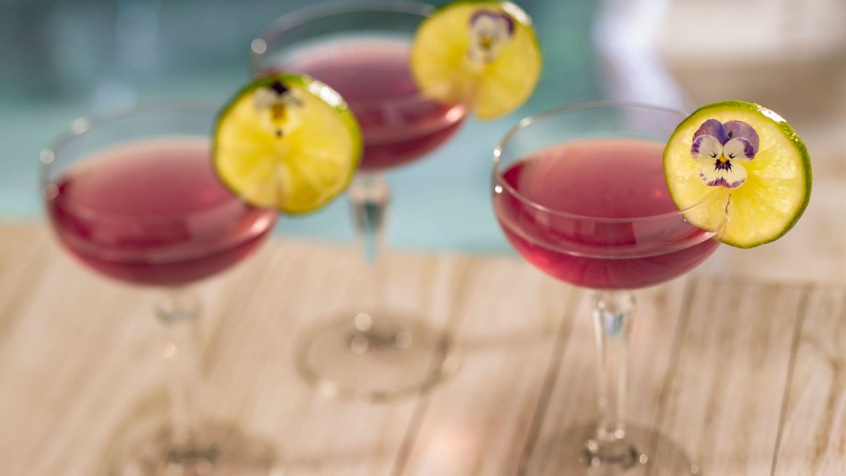 Three drinks served in glasses with lime slices