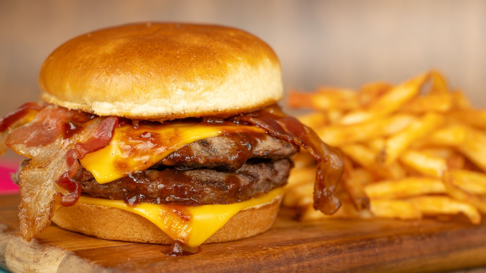 Una hamburguesa con queso con 2 hamburguesas de carne de res, queso, tocino y un acompañante de papas fritas