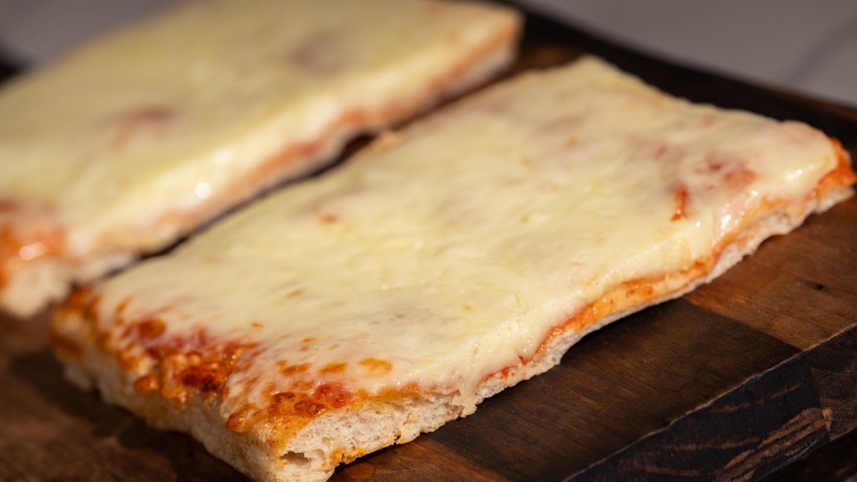 Two slices of Sicilian style cheese pizza