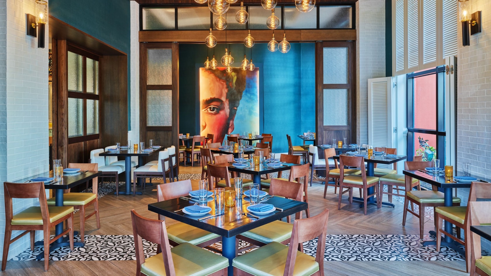 Un comedor con decoración moderna y un gran retrato de la artista Frida Kahlo