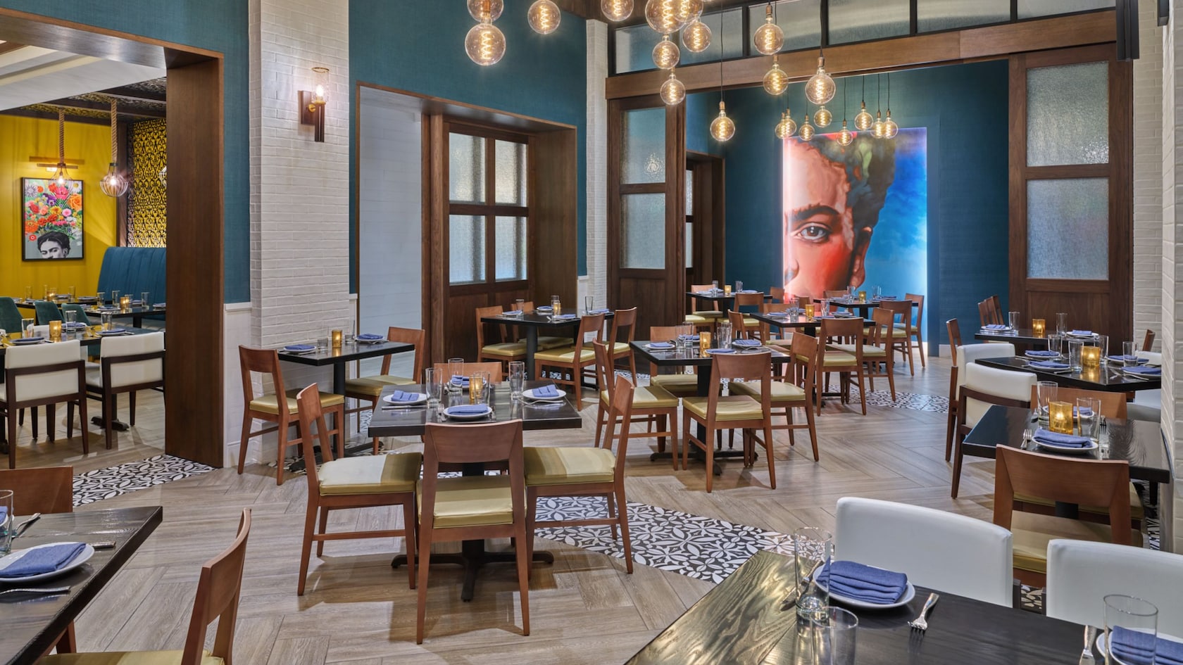 Dos comedores, ambos con decoración moderna y arte mural de la artista Frida Kahlo