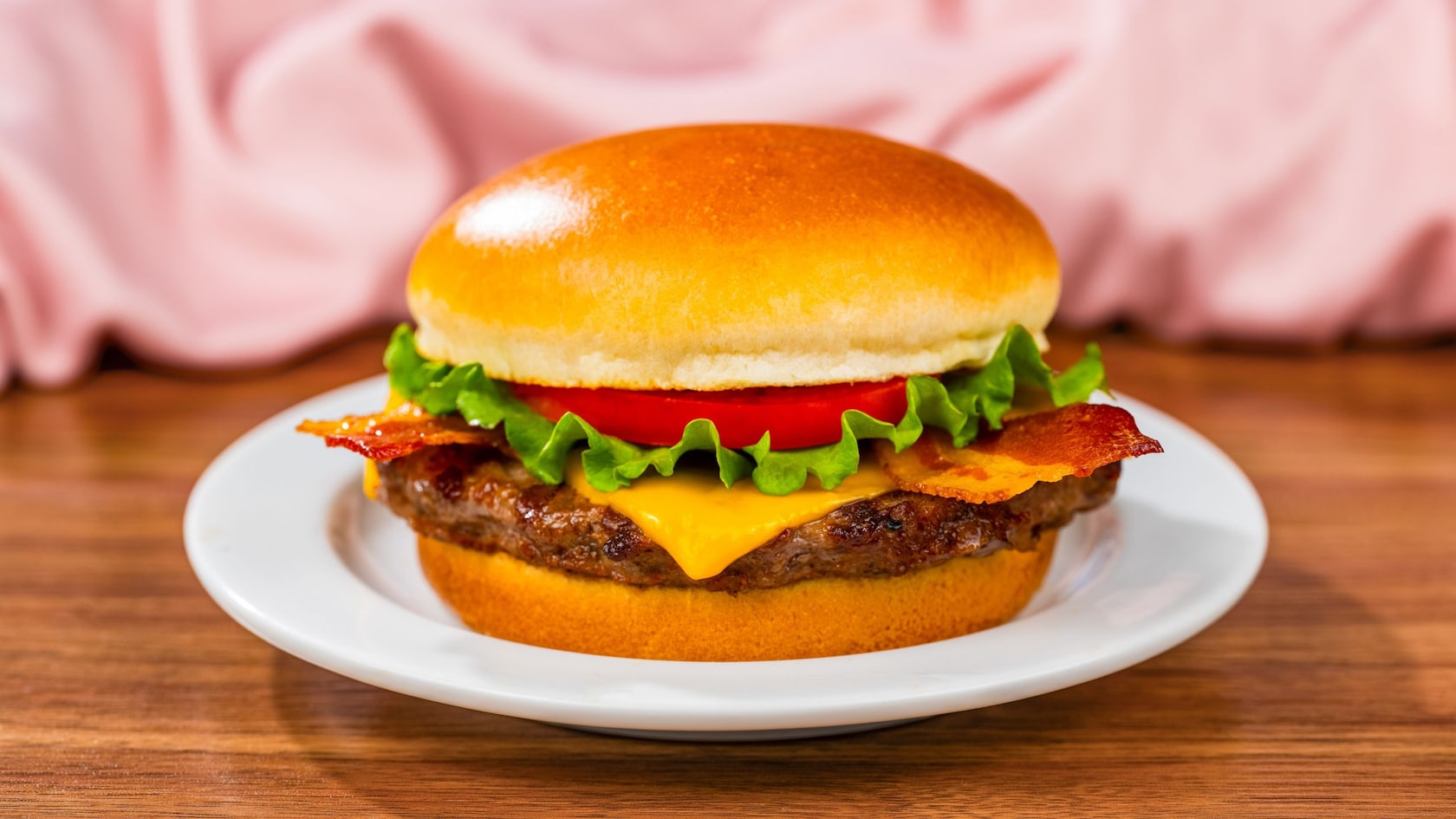 A cheeseburger with tomato and lettuce