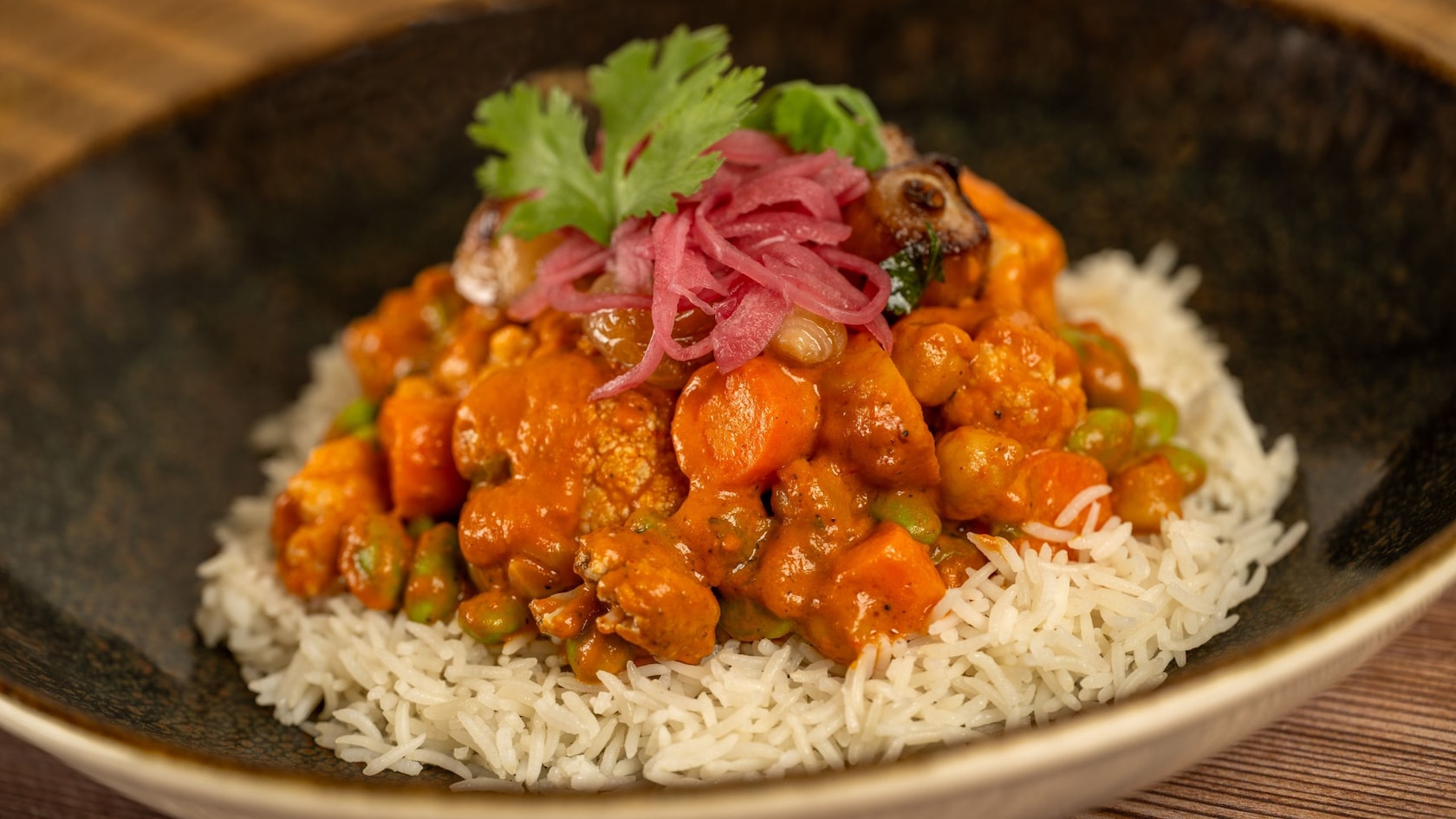 A curry dish served on a bed of rice in a bowl