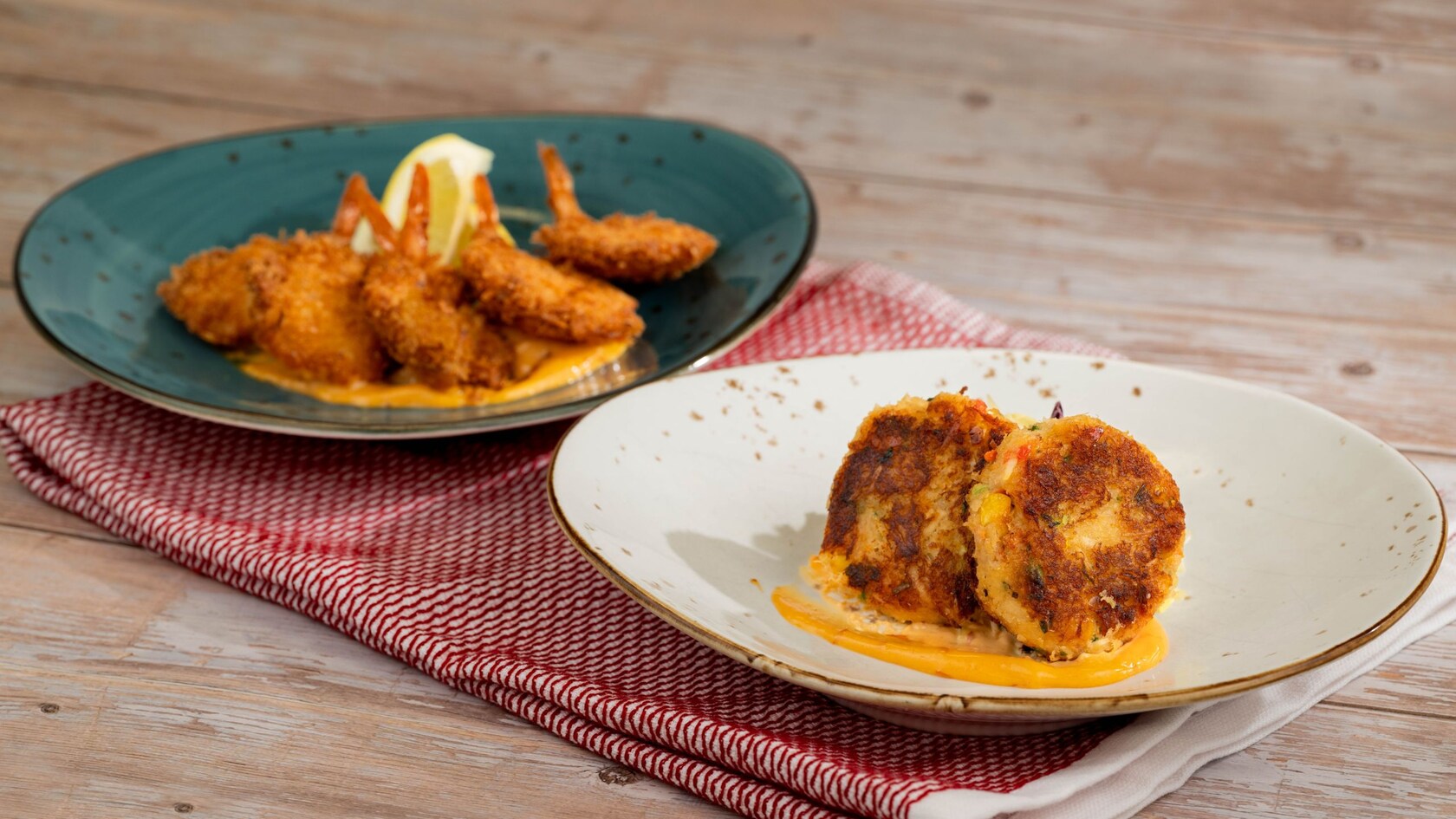 A plate of Crab and Seafood Cakes and a plate of Fried Coconut Shrimp