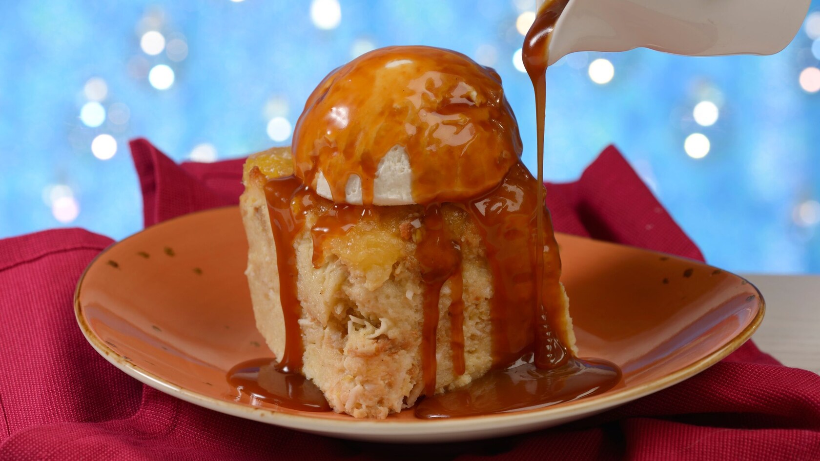 Sauce being poured over bread pudding