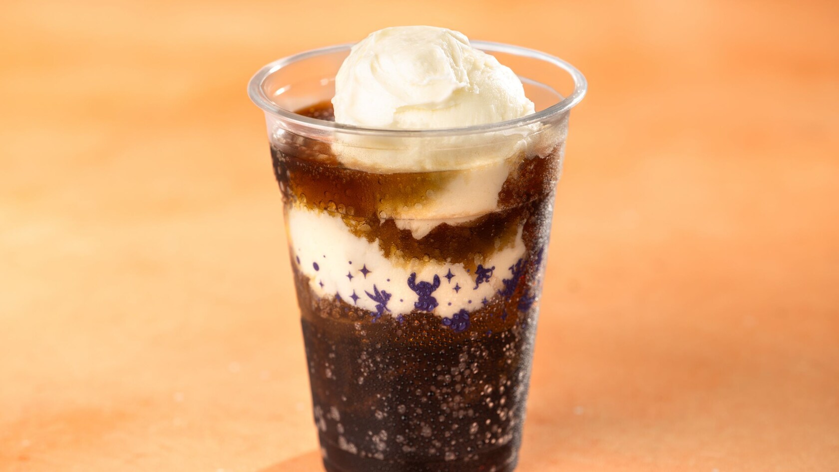A soda float in a plastic cup with a starry design 