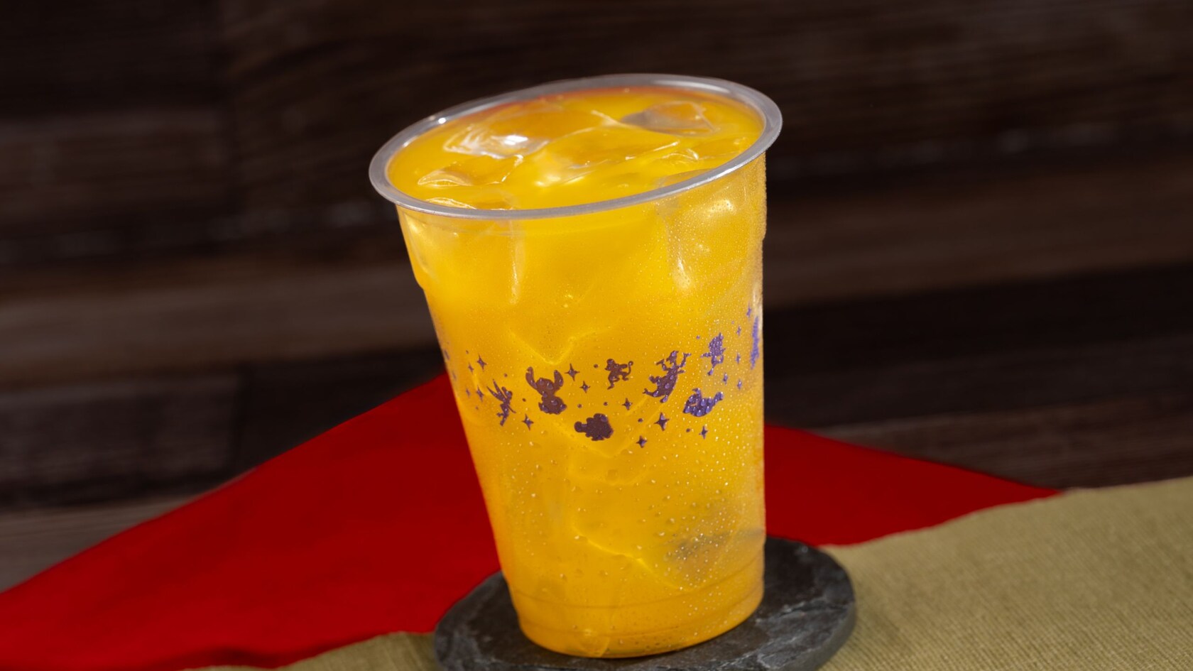 A large cup of cold, refreshing juice with ice, resting on a drink coaster