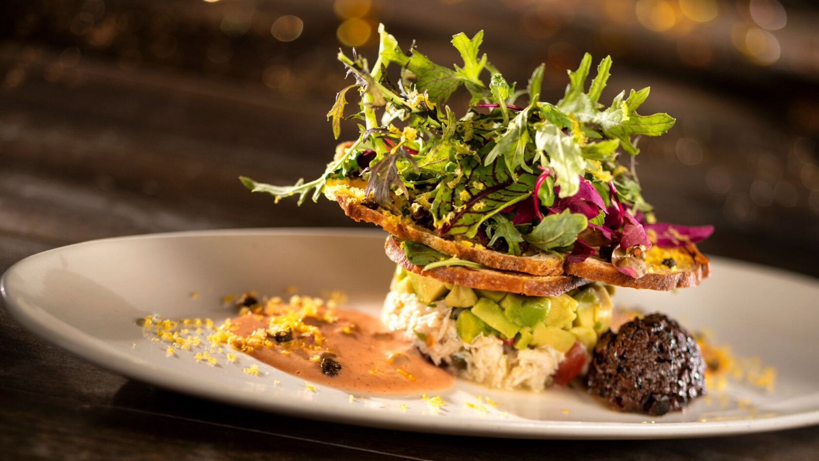 Olive bread, a citrus blend, capers and sauce on a plate