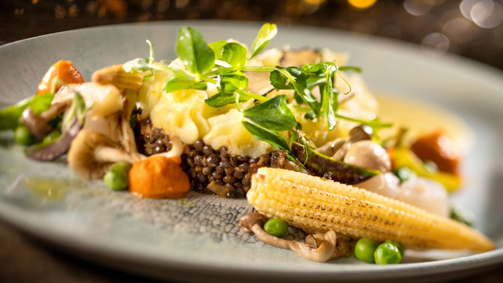 Mashed potatoes, mushrooms, peas and corn on a plate