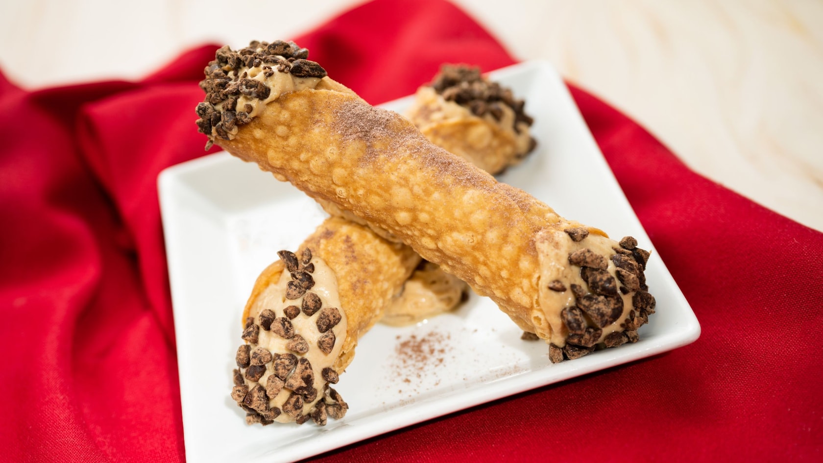 2 cannolis on a plate with chocolate chips