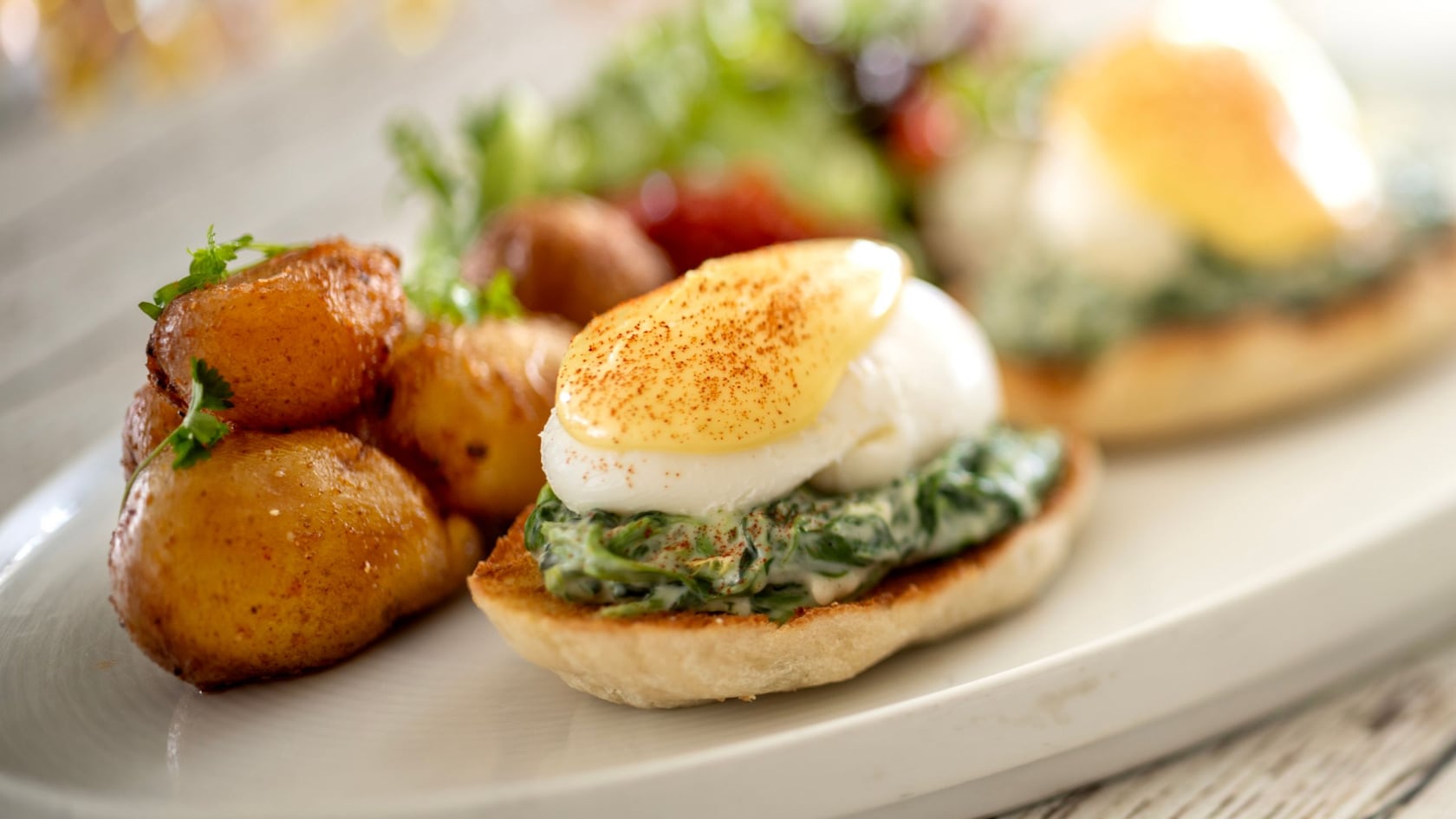 Huevos benedictinos a la florentina de Topolino's Terrace, Flavors of the Riviera, servidos con papas alargadas y una ensalada