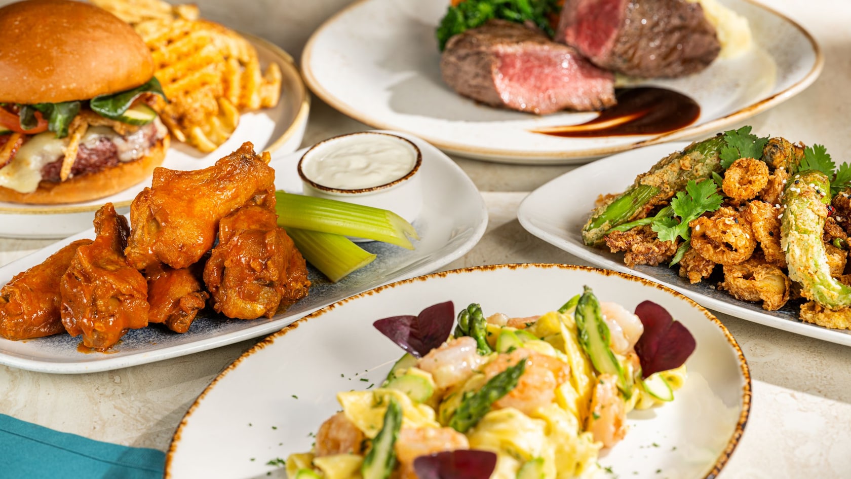 Assorted dishes including a Turf Club Burger, Crispy Chicken Wings and Golden-Fried Calamari