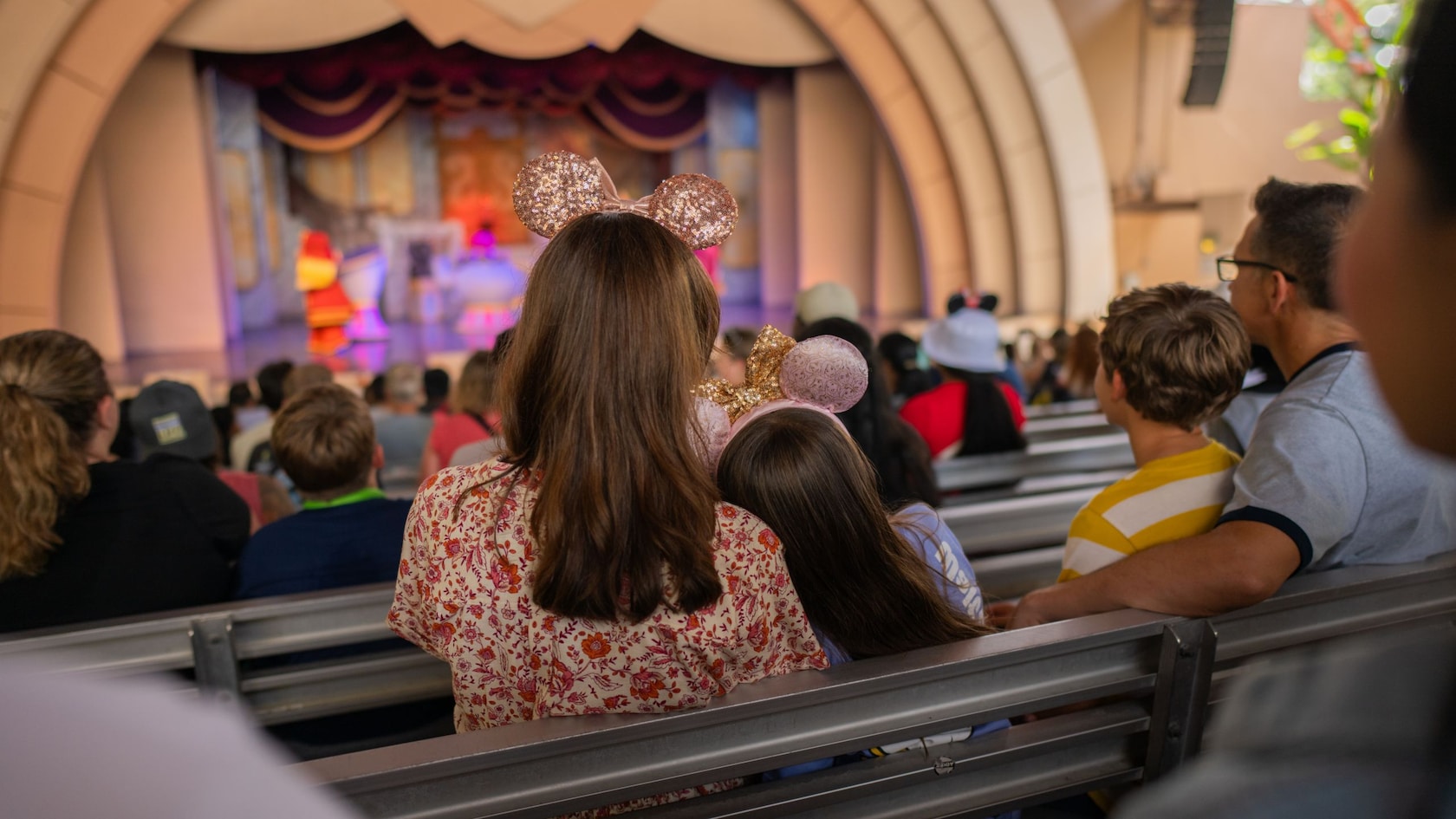 A family of 4 and other Guests watching the Beauty and the Beast Live on Stage show from the stands