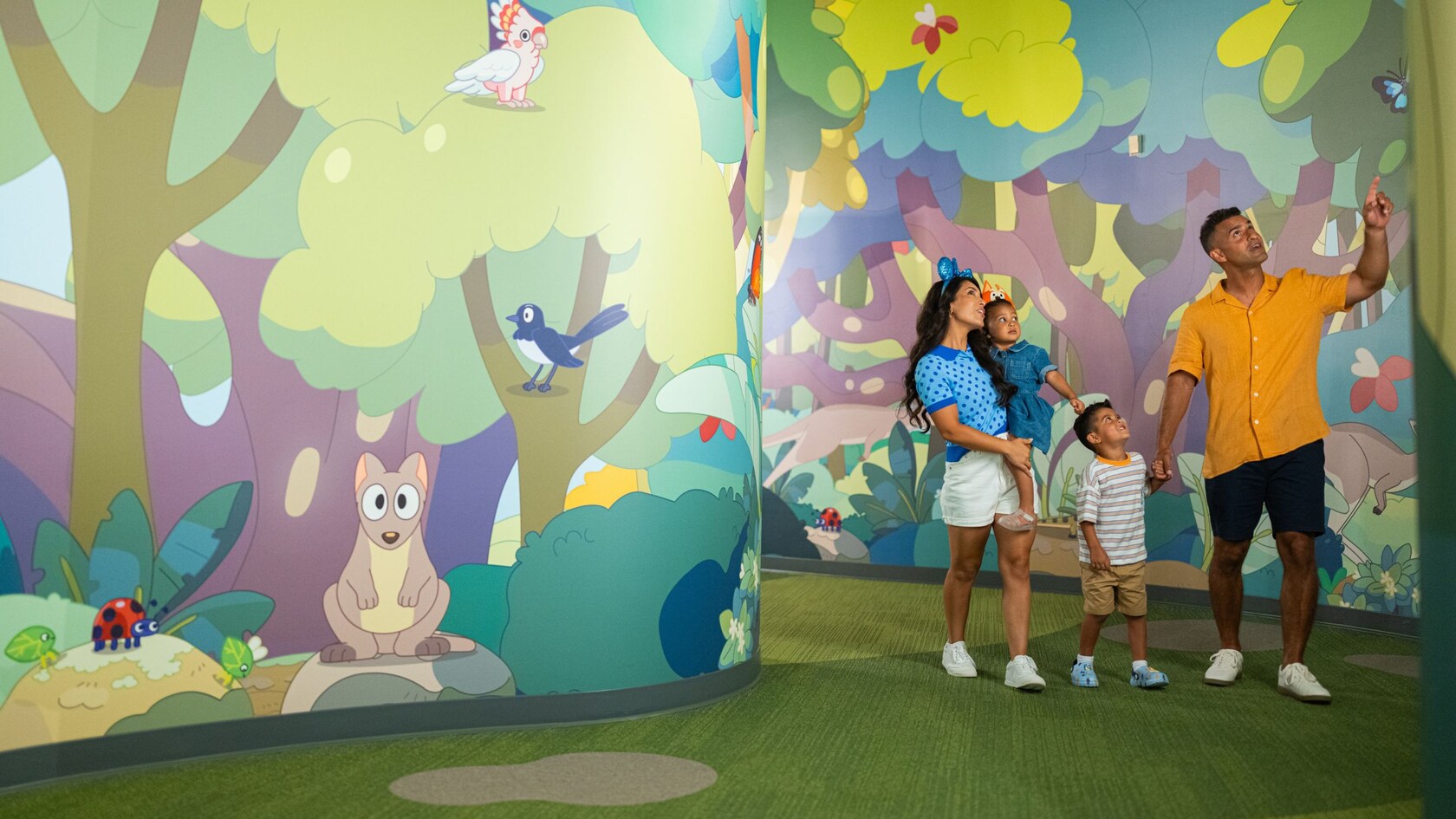 A family walks through the nature themed halls of Bluey’s Wild World