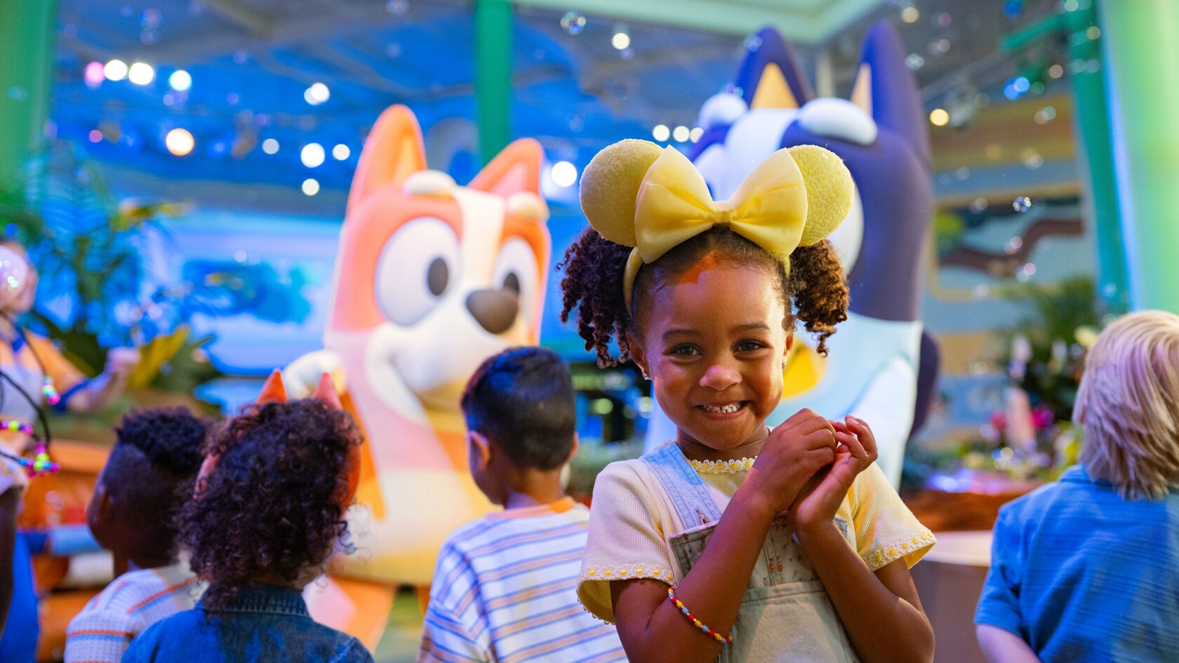A girl smiles in front of Bluey and Bingo 