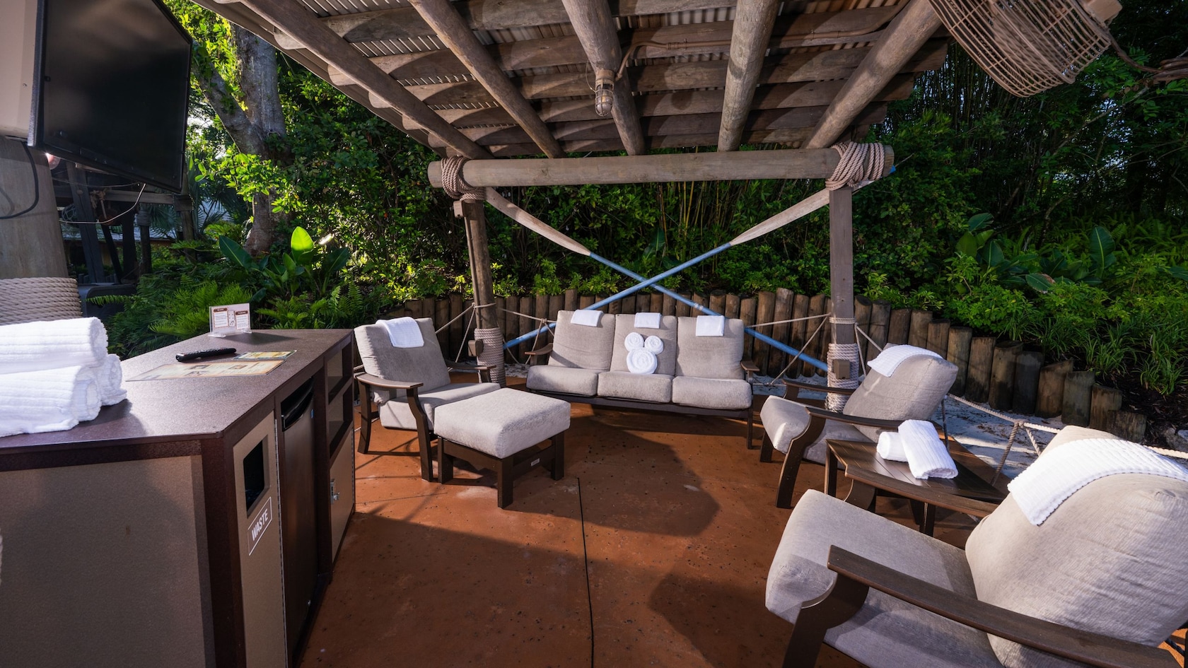 Beachcomber Shack Premium Plus seating area with cushioned chairs, towels, TV and mini fridge
