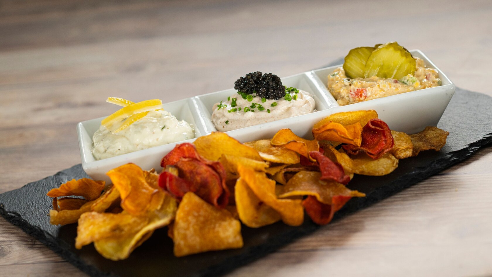 A Trio of Dips garnished with lemon, fish roe and pickles