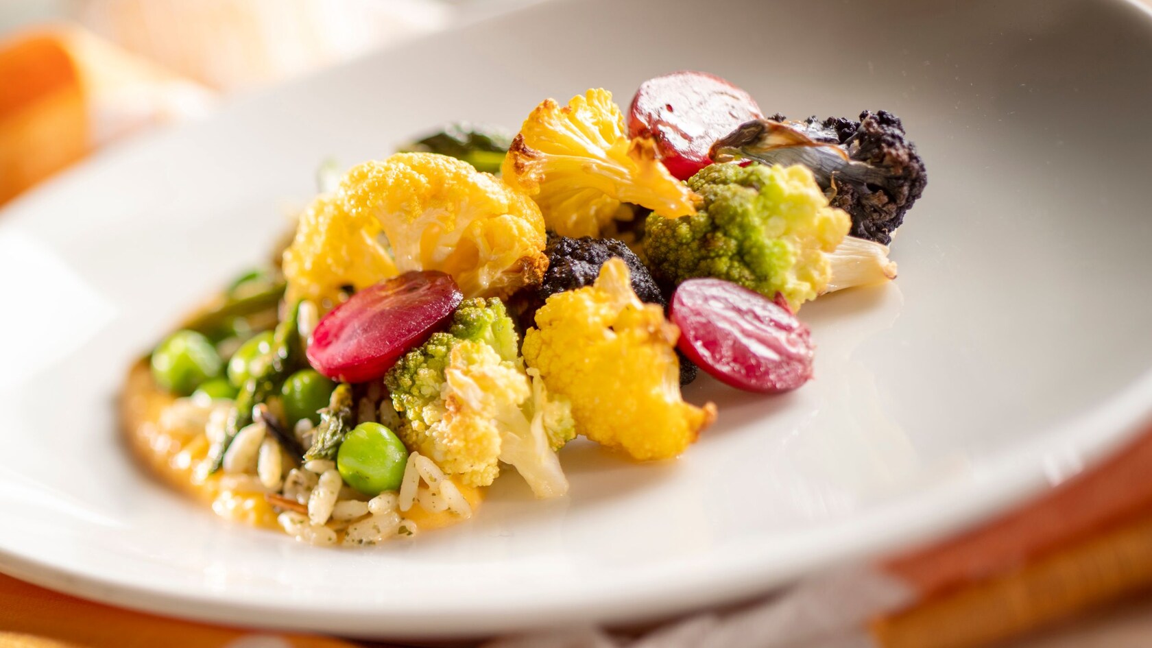 Honey Glazed Cauliflower with carrot purée, wild rice pilaf, spring vegetables, grapes and sunflower brittle