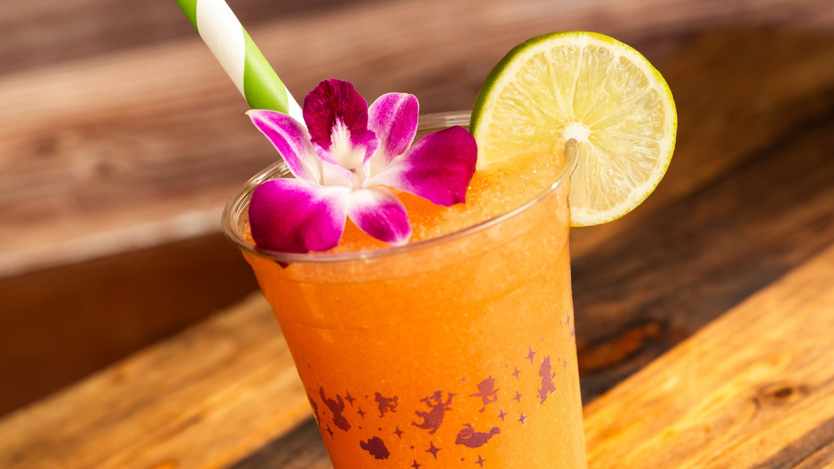A Peach Lime Smoothie topped with a flower accent and slice of lime on the rim