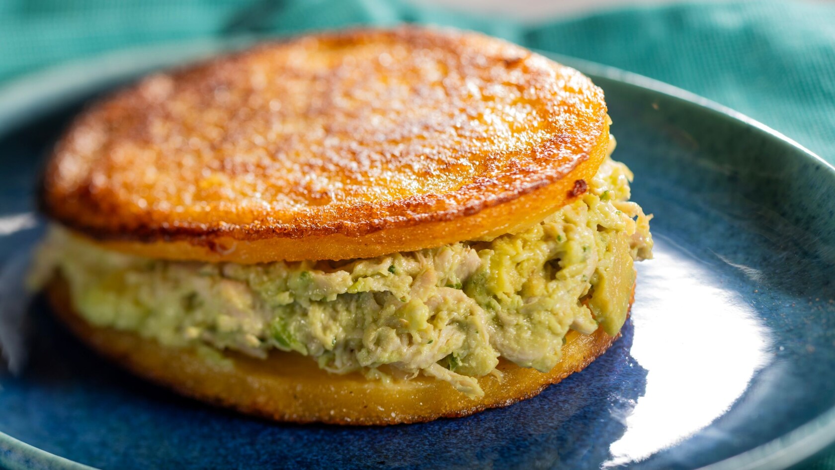 Una arepa rellena de pollo y aguacate